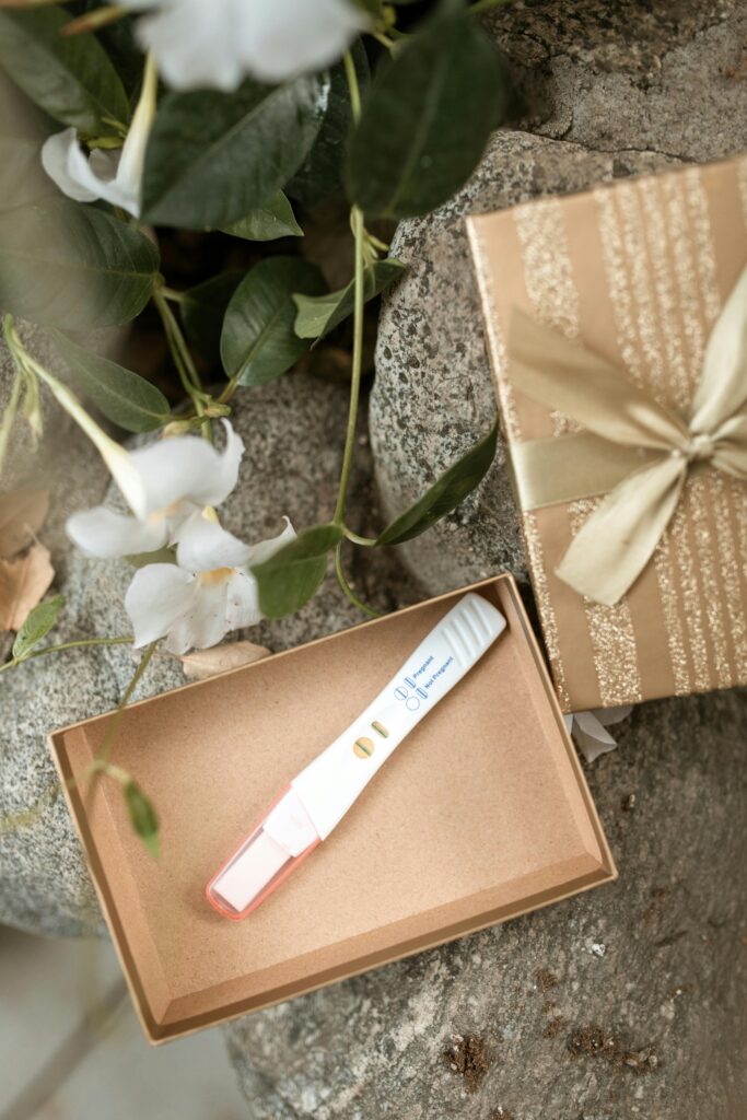 pexels-photo-6148916-6148916 Positive pregnancy test displayed in a decorative gift box with flowers.